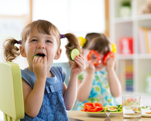 Zwei Mädchen am essen im Kindergarten München