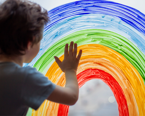 Junge am Regenbogenfenster im Kindergarten München