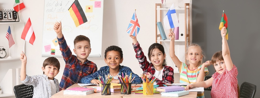 Glückliche Kinder halten verschiedene Länderflaggen in der Hand