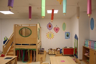 Heller Spielraum mit bunten Bleistift-Dekorationen an der Decke und kindlichen Wandgemälden.